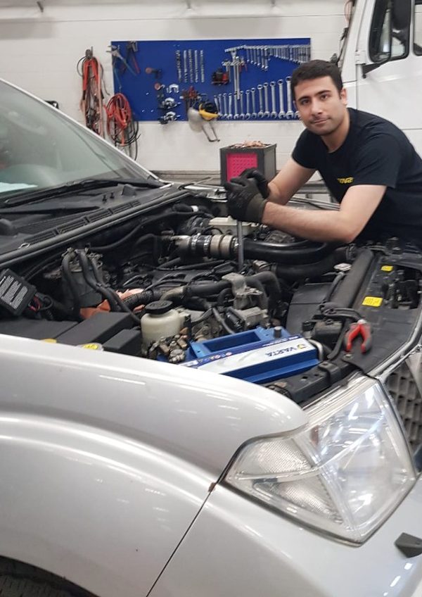 Habib Alwko arbetar i motorrummet på en bil